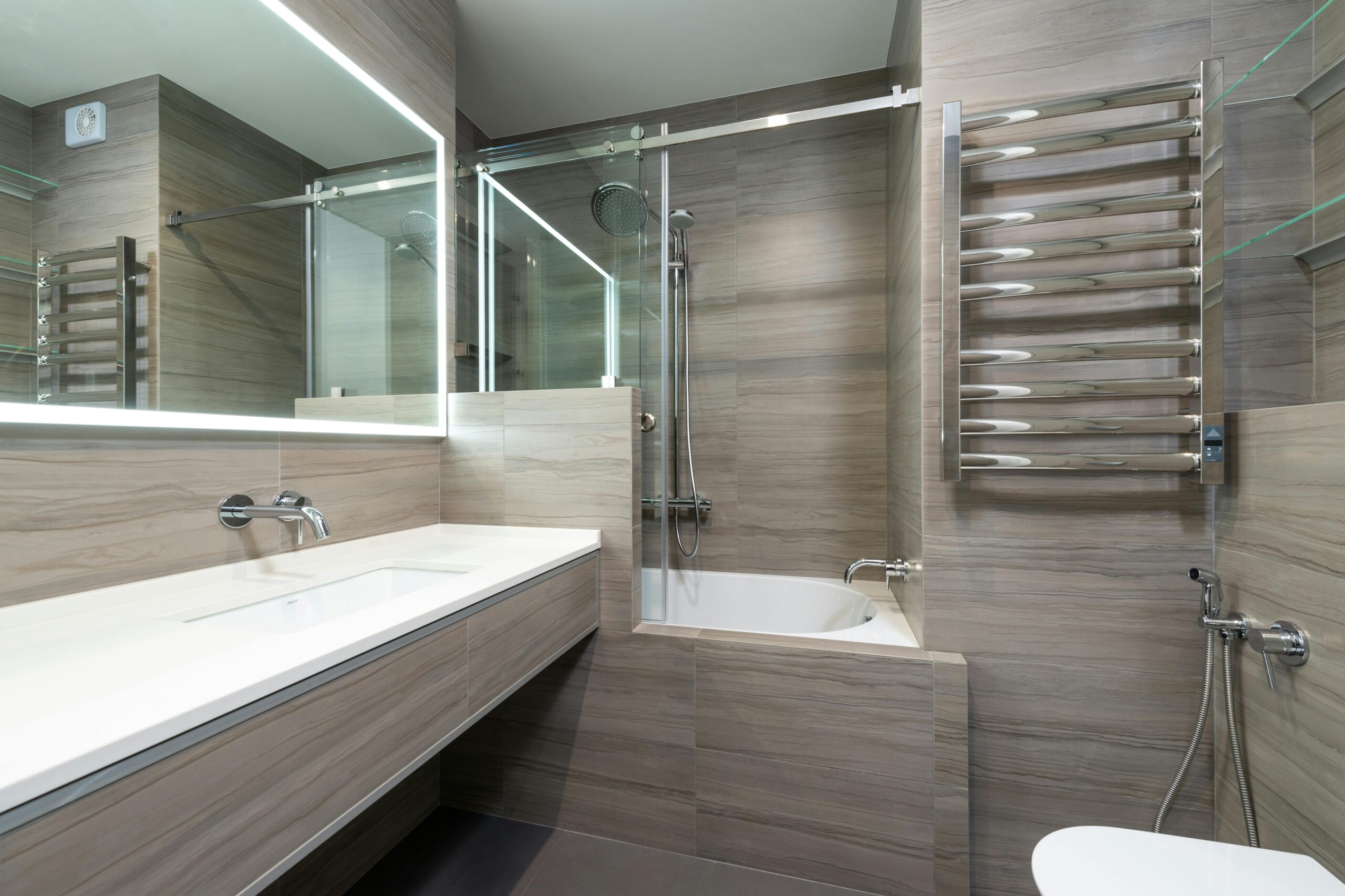 Elegant modern bathroom featuring a bathtub, shower, and sleek stainless steel fixtures.